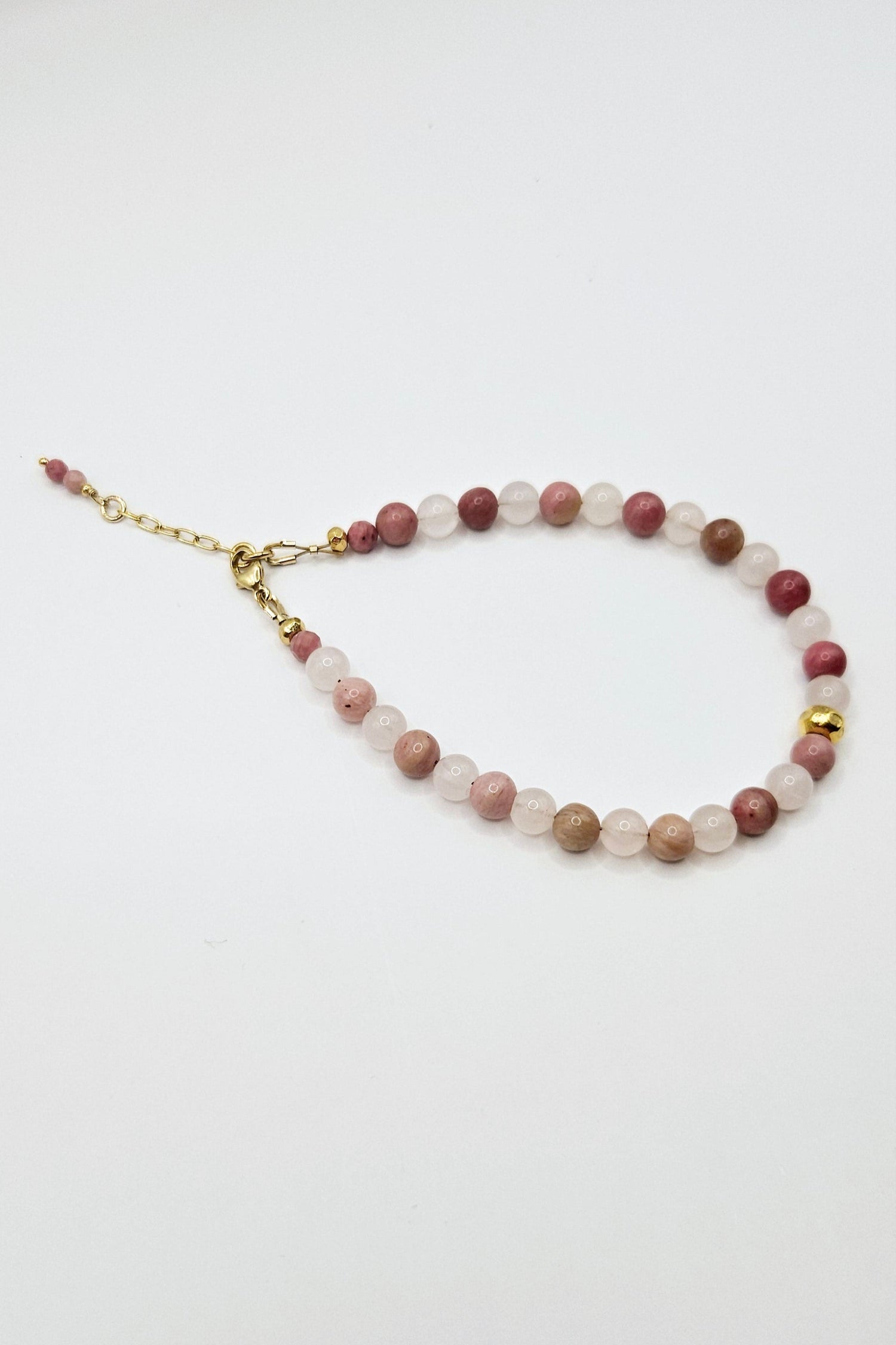 Product image of a Soul & Stone Rhodonite and Rose Quartz Beaded Bracelet laying on a white background.